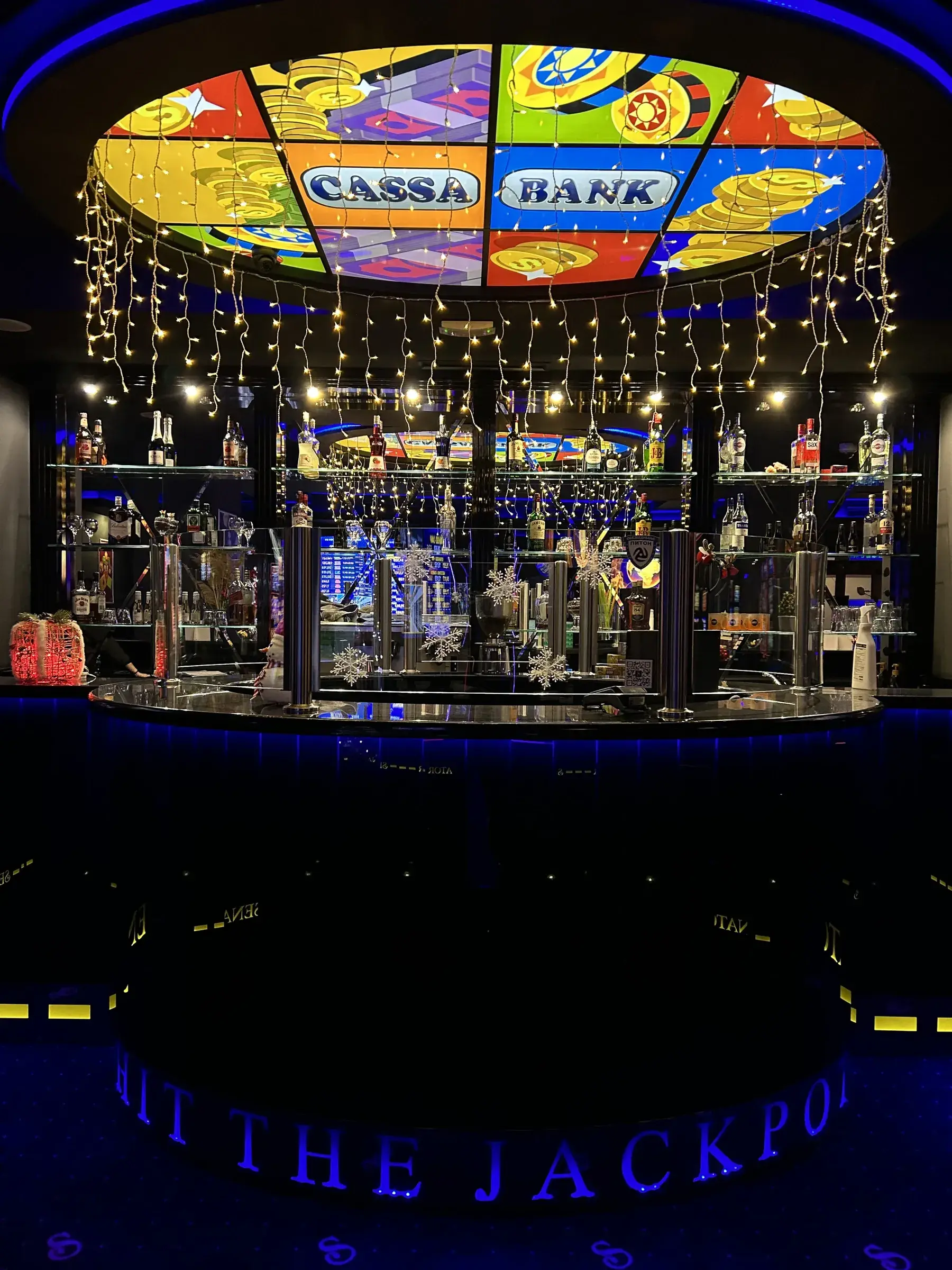 The circular club bar and its spirits shelf under a stained glass dome that reads Cassa Bank