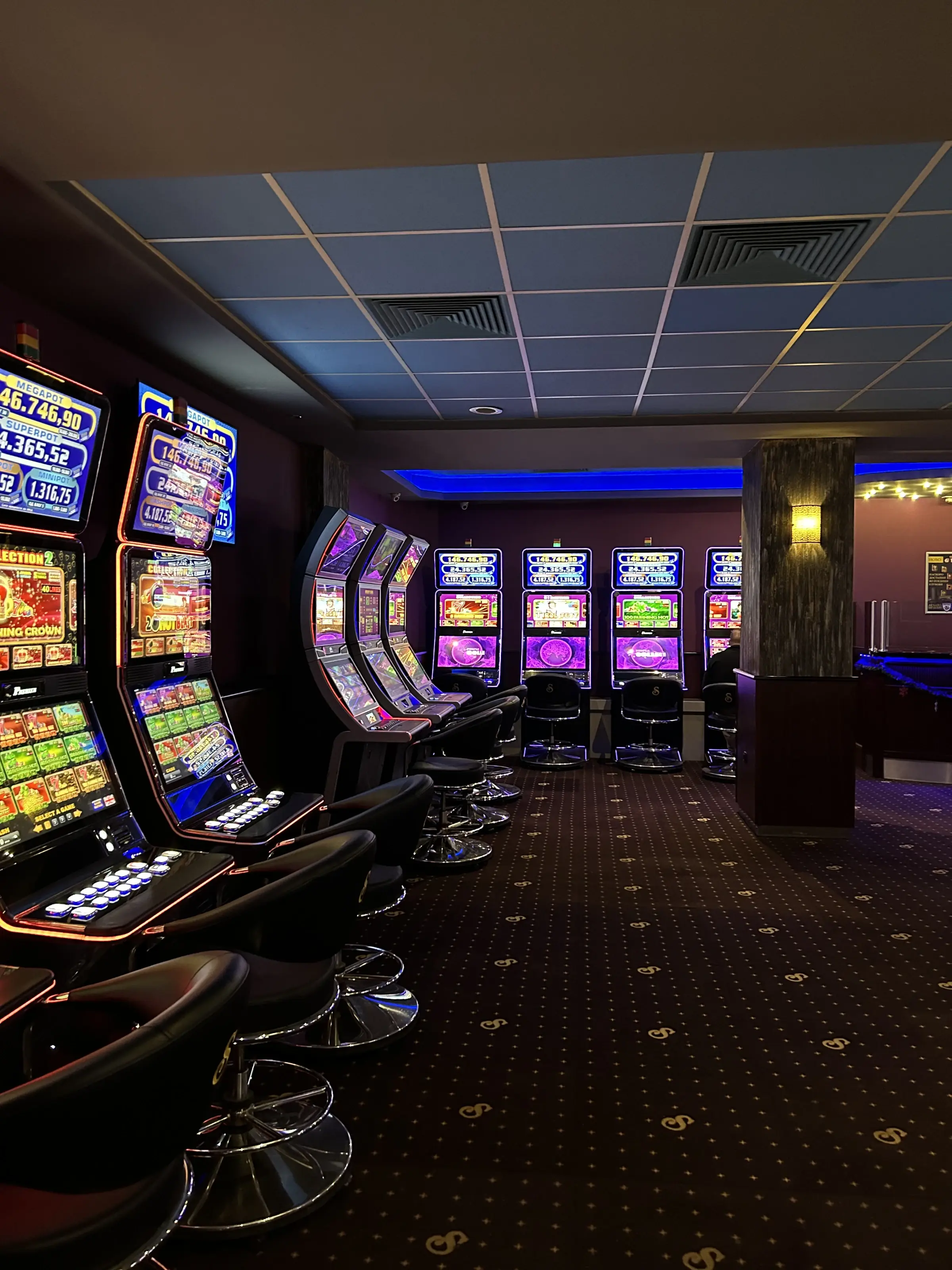 A curved line of slot machines with their jackpot displays lit above