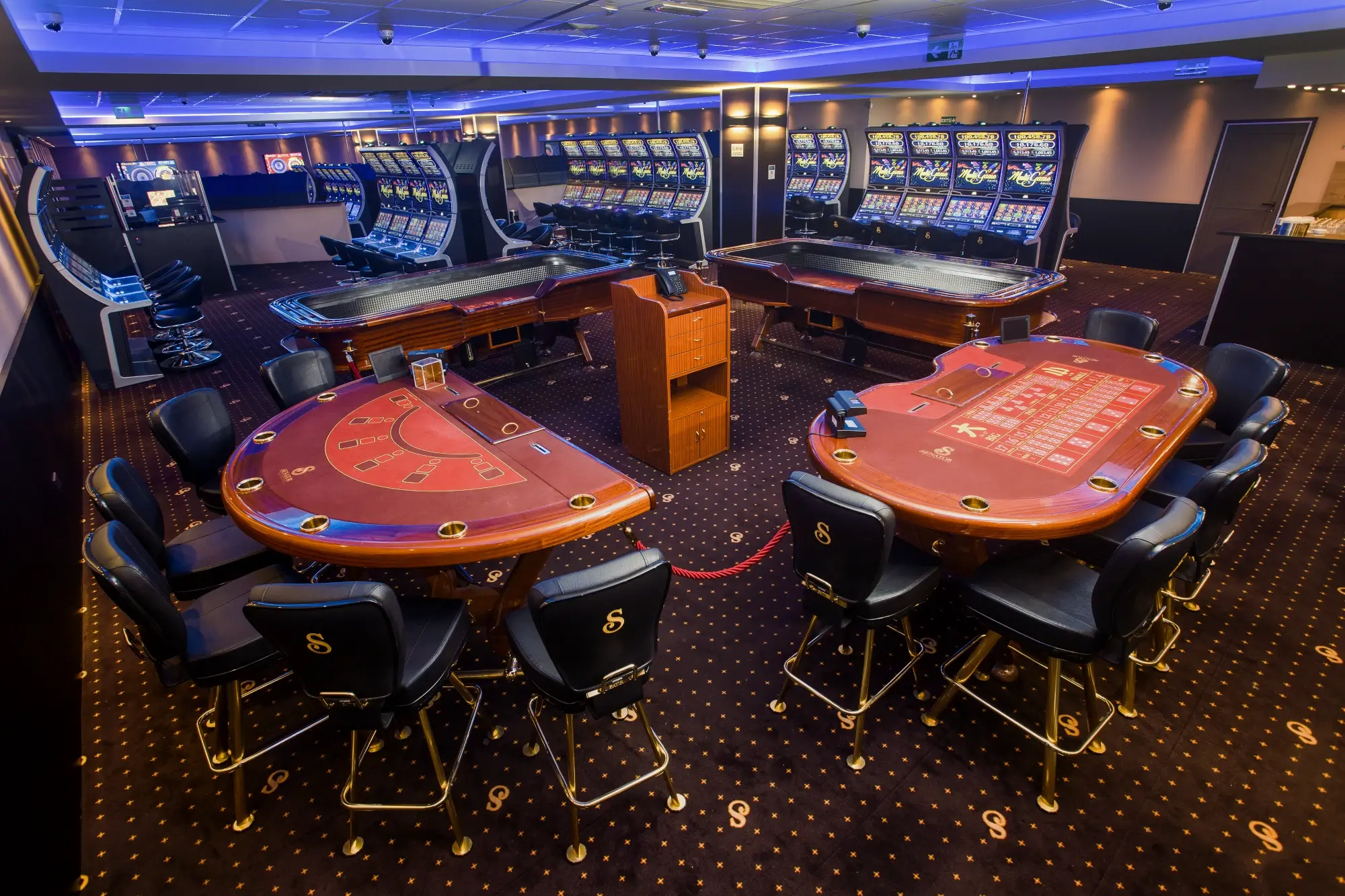 Two red card tables side by side behind a rope, with two long tables and the slot line behind them, Senator Club, Mauritius